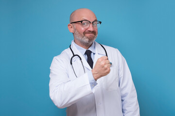 Happy successful mature man showing fist. Doctor has done all his tasks and is satisfied with results.