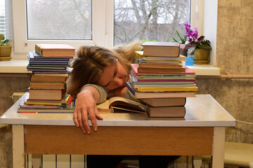 The student tired of reading books fell asleep at the table.