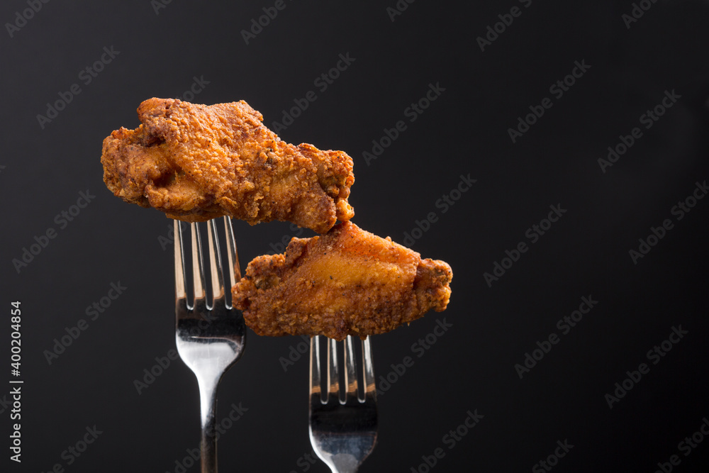 Wall mural Breaded Fried chicken wings drum and flat on a fork with copy area