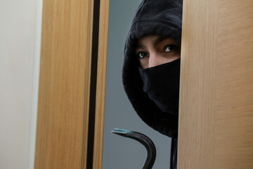 Thief broke into the apartment. House robbery by woman in a black jacket and black mask and...