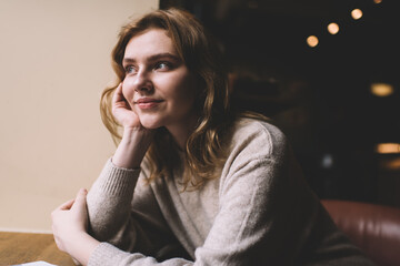 Young charming woman sitting in cafe and dreaming