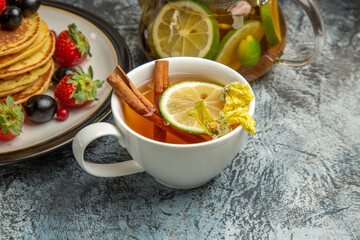 front view delicious pancakes with cup of tea on light background tea fruit cake