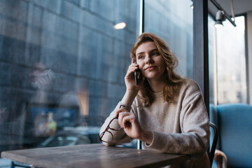 Concentrated woman speaking on cellphone in cafe