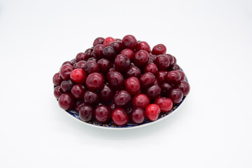 Ripe cherries stacked with a slide on a saucer