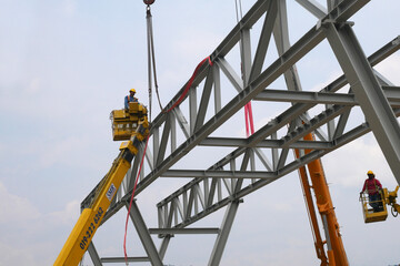 MALACCA, MALAYSIA -MARCH 12, 2020: Construction workers working at height at the construction site. They are supplied with harnesses and other safety equipment to prevent them from having an accident.