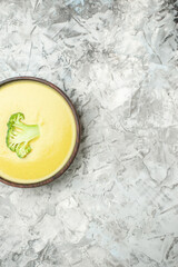 Vertical view of cream of broccoli soup in a brown bowl on white background stock image