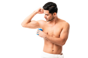 Fototapeta na wymiar Man takes care of his hygiene by applying deodorant to his armpit