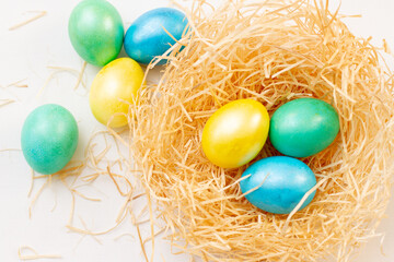 Fototapeta na wymiar Colorful easter eggs in nest, top view