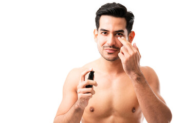 Fototapeta premium Hispanic man applying anti-aging cream