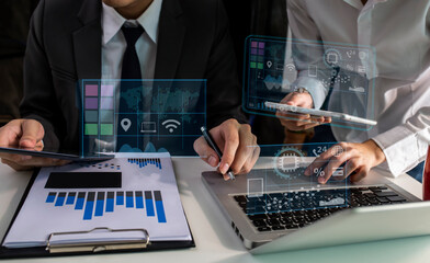 Businessman using digital tablet and laptop analyzing sales data and economic graph chart. Business strategy. Digital marketing and business innovation technology interface concept
