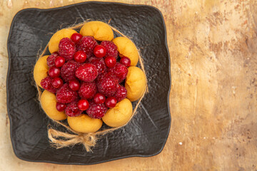 Top view of a gift cake with fruits on the right side of mixed color backgroundTop view of a gift cake with fruits on the right side of mixed color background