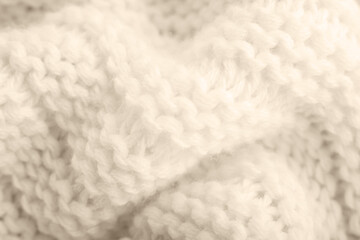 Close up of beige knitted textured background.