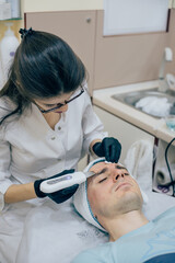 Men`s cosmetology. Young male receiving facial procedures at beauty clinic