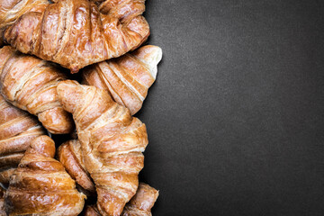 freshly baked croissants on the breakfast on a black background. black background can be used for your text