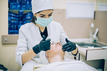 young woman with problem skin receiving mesotherapy facial treatment in beauty clinic