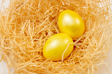 Fototapeta na wymiar Easter flat lay of golden Eggs in yellow nest