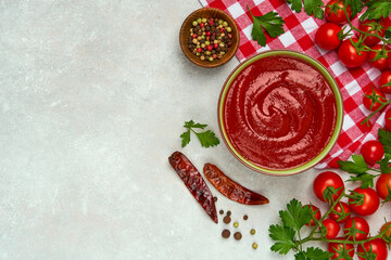 Bowl of tomato sauce and cherry tomatoes . Top view, copy space