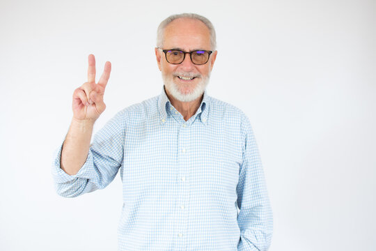 Senior grey-haired man wearing casual shirt standing over isolated white background smiling with happy face looking at the camera doing victory sign with fingers. Number two.