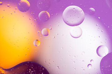 Abstract colorful background of the oil on water surface in yellow, white and lilac shades.