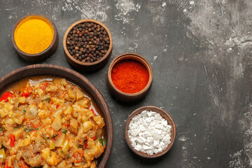 bottom view roasted eggplant salad in bowl different spices in small bowls on dark background free space