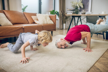 Good-looking fit man doing yoga with his son