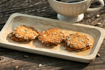 sunflower seeds cookies with cup of coffee placed on old wooden table