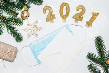 protective face mask and an envelope on the table. Preparing for the New Year and Christmas. The background for New Year's greetings with the new reality of 2021 in trendy gold colors.