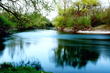 Fototapeta na wymiar Donaukurve mit natürlichem Ufer und verwaschenem Wasser