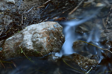 Umschwämmter Stein im Fluss am Abend