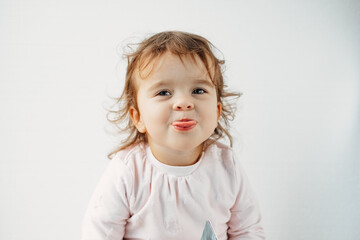 Naklejka premium a child on a white background shows his tongue in his mouth, emotions.