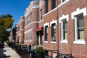 Row of Old Brick Residential Buildings along a Sidewalk in Astoria Queens New York