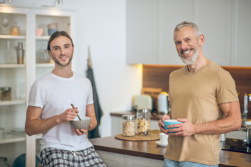 Smiling couple standing in the kitchen and looking happy