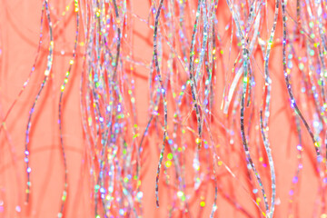 festive holographic tinsel fringe detail on coral red background