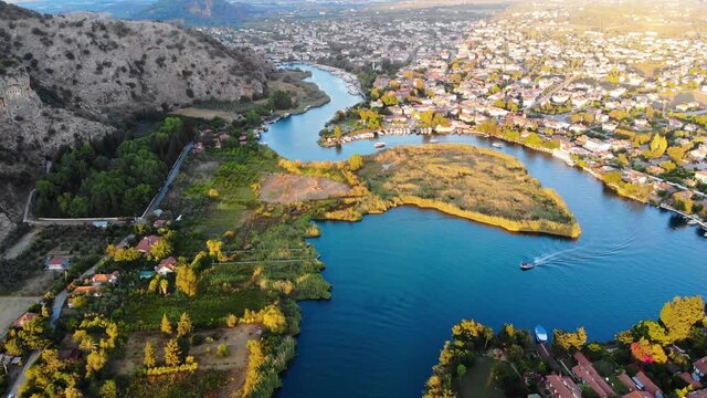 Aerial view winding blue river and small town at sunset. Drone shot. Dalyan, Turkey. 4K