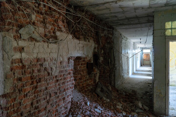 Renovation in the apartment. Destroyed buildings after an earthquake or cataclysm. Walls without plaster and broken red brick. Lack of windows and doors in abandoned apartments.