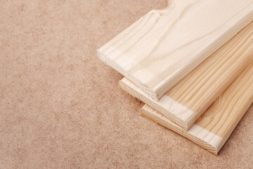 Wooden boards are stacked on top of each other. Slats for assembling furniture shelves. The table is covered with pressed paper hardboard.