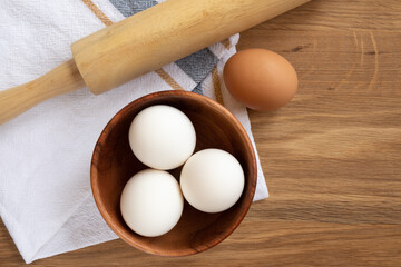 Baking ingredients - eggs inside a wooden plate and rolling pin.