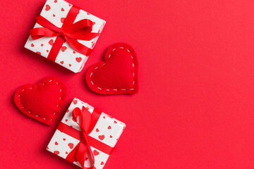 Top view colorful valentine background made of gift boxes and red textile hearts. Valentine's Day concept with copy space