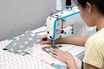 girl sews on a sewing machine