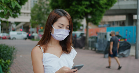 Woman wear face mask and use of mobile phone at street