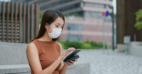 Woman wear face mask and use of mobile phone