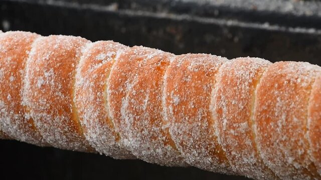 Close up chimney cake baking and rolling