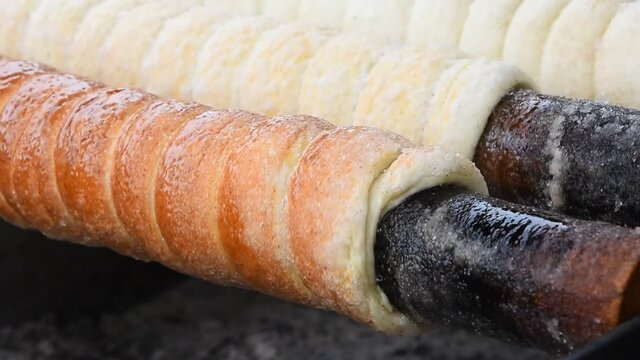 Close up chimney cake baking and rolling