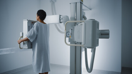 Hospital Radiology Room: Beautiful Latin Woman Standing Next to X-Ray Machine While it Scans Back....