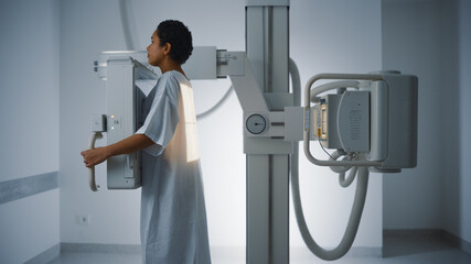Hospital Radiology Room: Beautiful Latin Woman Standing Next to X-Ray Machine While it Scans Back....