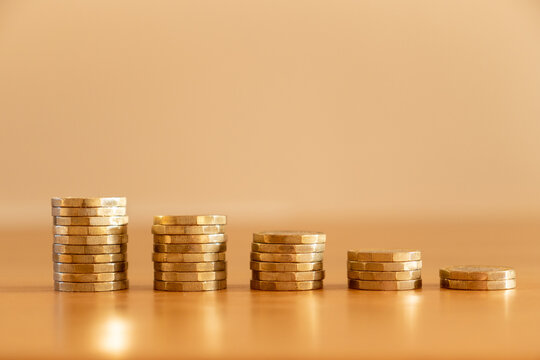 Close Up Of Stacks Of Many GBP One Pound Coins Decreasing In Size As Money Going Down Symbolising The Effects Of Inflation, UK