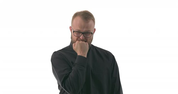 Portrait of young Caucasian priest biting his fist trying to suppress emotions. Body language. Isolated on white background
