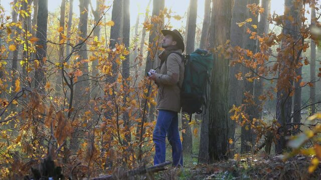 Tourist travels in the autumn forest. Man photographs the landscape using a retro camera. Travel concept. 4K