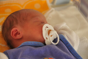 Sleeping baby with large dummy