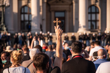Orthodox believers protest in front of Assembly of the Republic of Serbia. A man in the crowd holds...